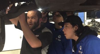 Auto mechanic Jake Sorensen shows technicians how to fix something on a car
