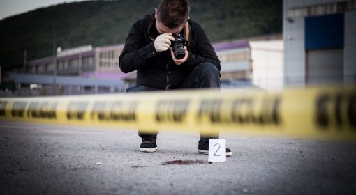 A criminal investigator takes photos at a crime scene
