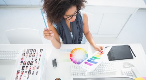 A graphic designer studies a color palette at her desk