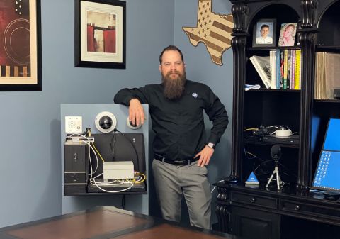 Casey Williams, security alarm tech, stands by a security system in ADT offices