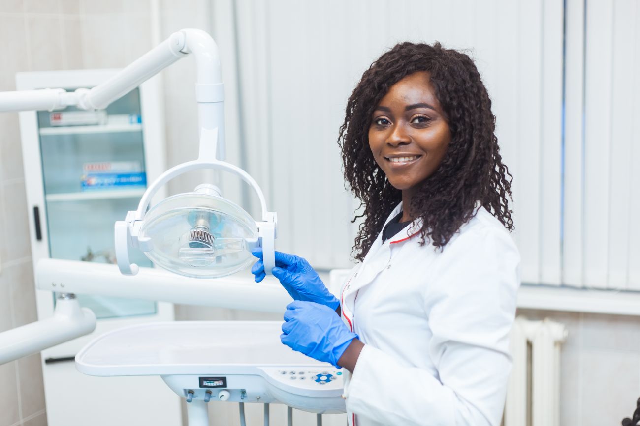 A dental assistant prepares dental equipment for a procedure