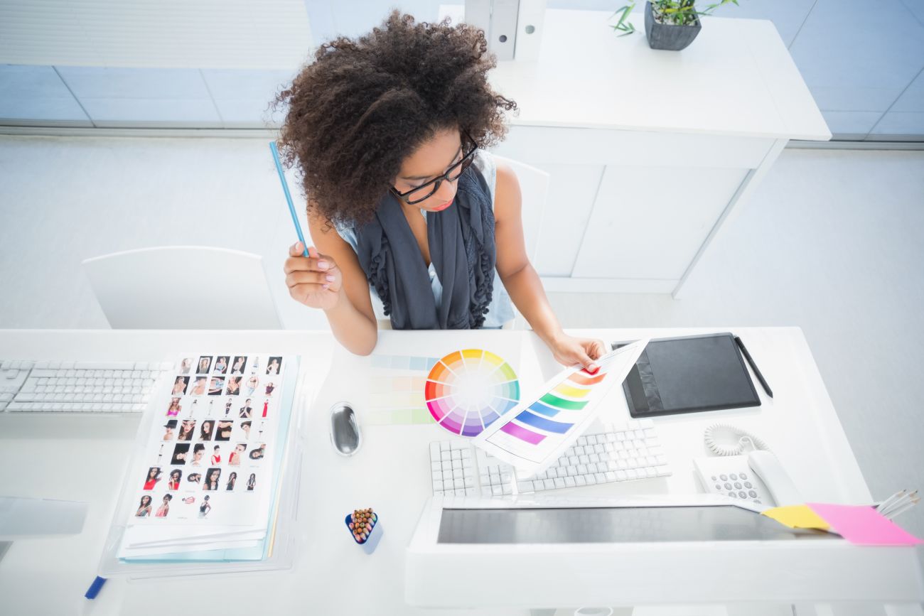 A graphic designer studies a color palette at her desk