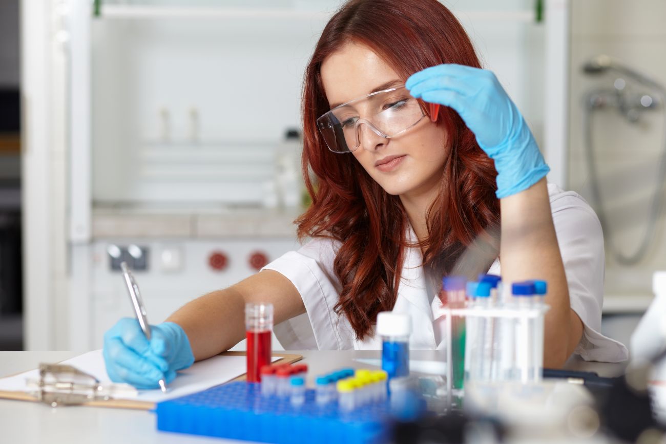 A lab technician works with samples and records the information