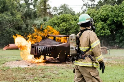 Firefighter extinguishing a car fire
