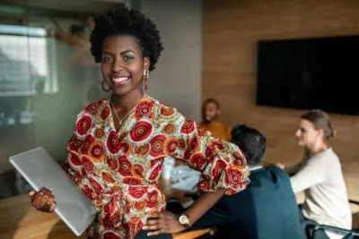 Confident black professional holding computer