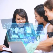 3 females using AI, looking at a computer