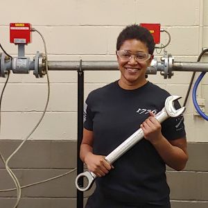 Electronic engineering technician Tracy Wilson poses with a large wrench