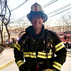 Firefighter Jeffrey Kaplan of New Jersey stands in front of a fire engine in his gear