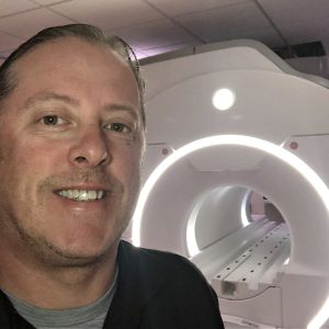 Joseph Seibert, MRI tech ambassador, stands in front of an MRI machine