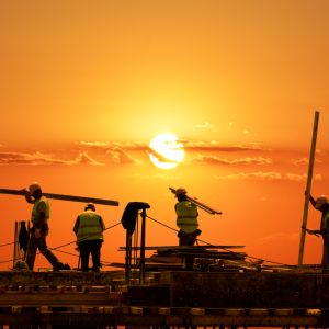 Sun sets over a construction site, representing infrastructure jobs