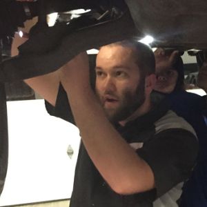 Jake Sorensen shows other auto mechanics how to fix a part on a car