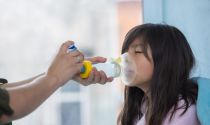 Respiratory therapist uses an inhaler to help a young girl experiencing breathing problems