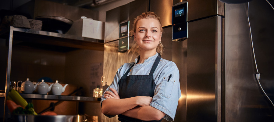 Woman chef standing proudly in a commercial kitchen